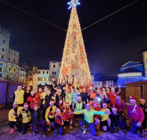Foto di gruppo di sera davanti a un grande albero di Natale